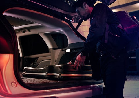 A man is shown loading cargo into the rear of a 2024 Lincoln Corsair® SUV with the second-row seats folded flat.