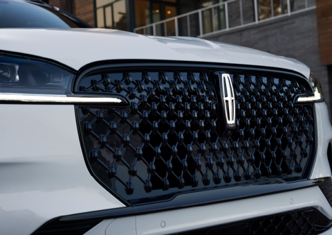 The black grille of a white 2025 Lincoln Aviator® SUV is shown with its fog lights on. | Greenwood Lincoln in Bowling Green KY