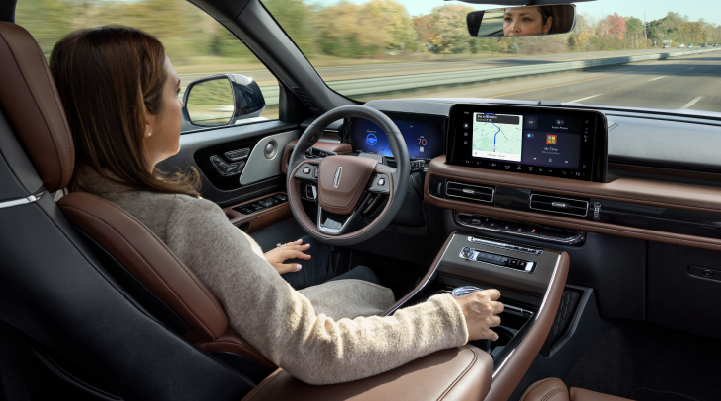 A woman is seen sitting in the driver’s seat of her 2025 Lincoln Aviator® SUV with her hands off the steering wheel. | Greenwood Lincoln in Bowling Green KY
