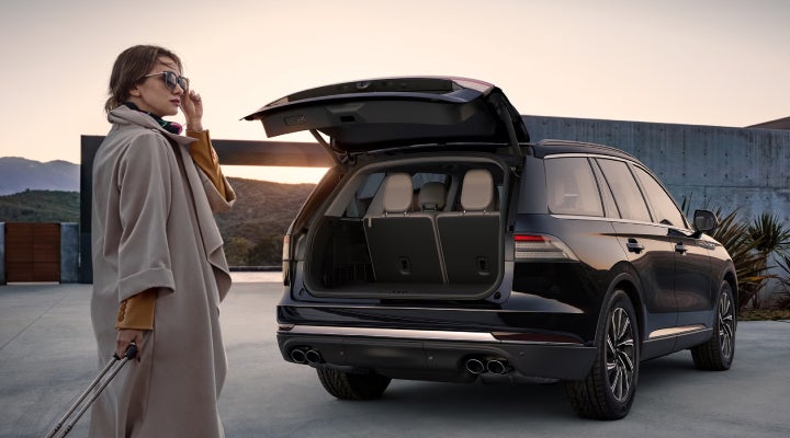 A woman approaches a 2026 Lincoln Aviator® SUV with its rear liftgate open. | Greenwood Lincoln in Bowling Green KY