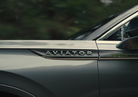 The driver’s side door and fender badging of a gray 2027 Lincoln Aviator® SUV are showcased. | Greenwood Lincoln in Bowling Green KY